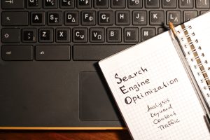 SEO notes beside a keyboard on desk